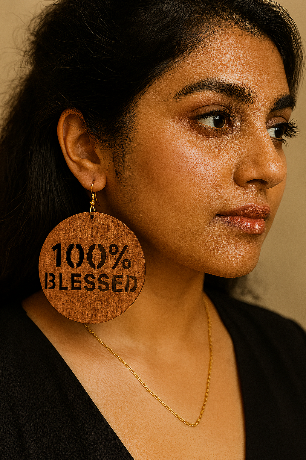 Woman wearing a wooden earring with '100% BLESSED' text.