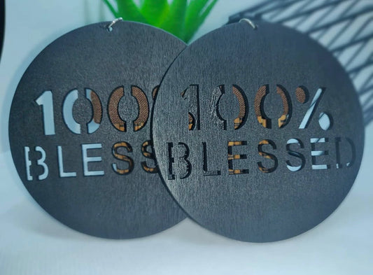 Black circular earrings with '100% Blessed' text on a white background