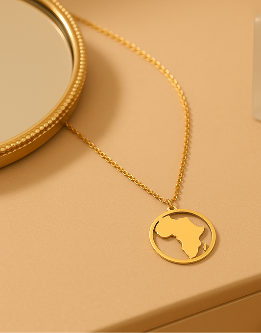 Gold necklace with a map of Africa pendant on a beige background
