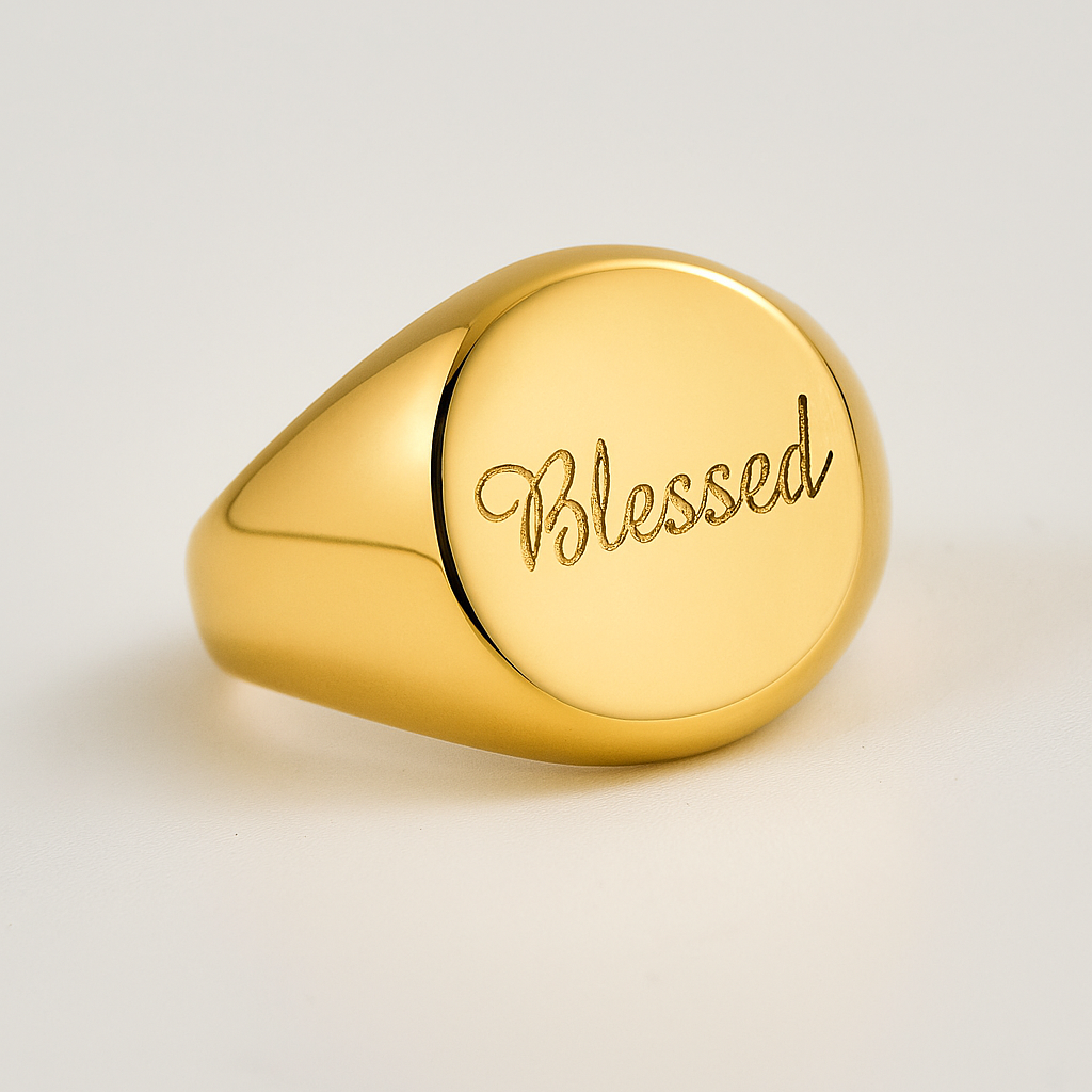 Gold ring with 'Blessed' engraving on a light background